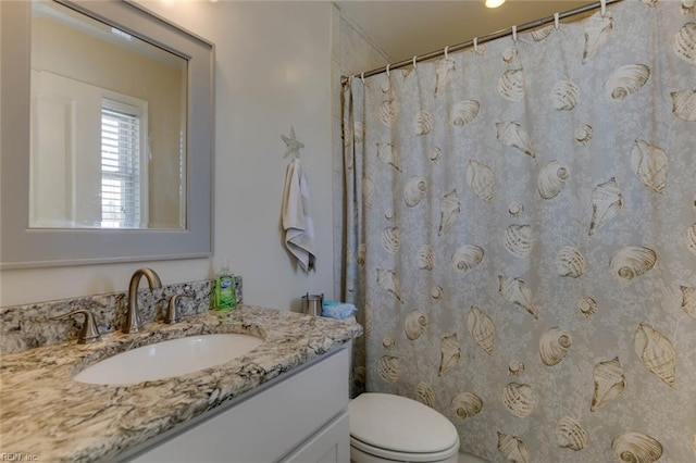 bathroom with toilet, walk in shower, and vanity