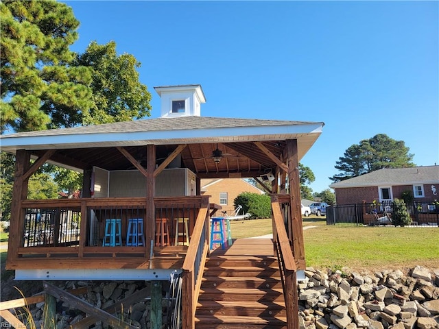 exterior space featuring a gazebo, a deck, and a lawn