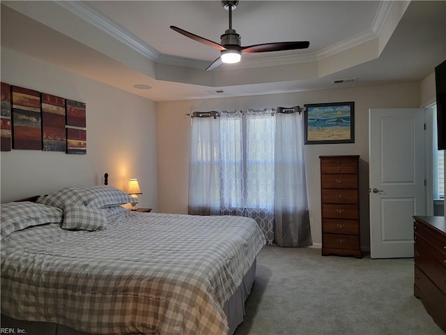 bedroom with ceiling fan, a raised ceiling, crown molding, and light colored carpet