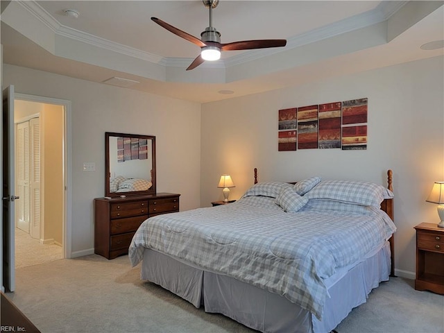 carpeted bedroom featuring crown molding, a tray ceiling, and ceiling fan