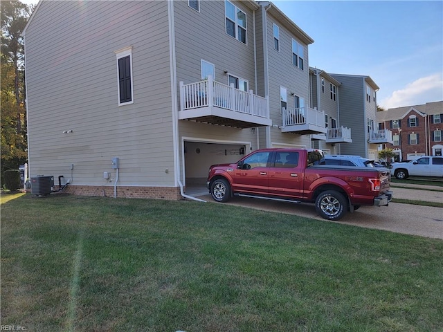 view of property exterior with a lawn, a balcony, a garage, and cooling unit