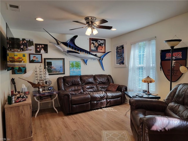 living room with ceiling fan and light hardwood / wood-style flooring