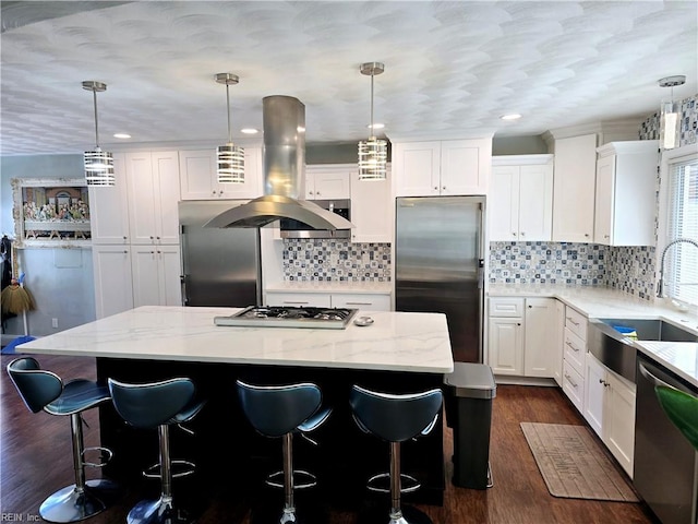 kitchen featuring dark wood-type flooring, stainless steel appliances, a center island, pendant lighting, and white cabinets