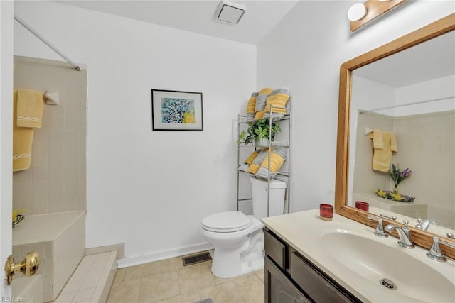 bathroom featuring vanity, toilet, tiled shower, and tile patterned flooring