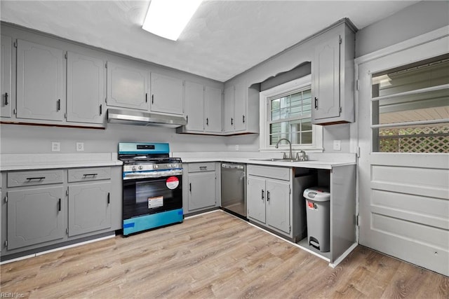 kitchen with gray cabinetry, dishwasher, light hardwood / wood-style floors, and range with gas cooktop