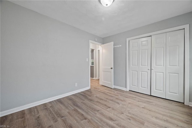 unfurnished bedroom featuring light hardwood / wood-style floors and a closet