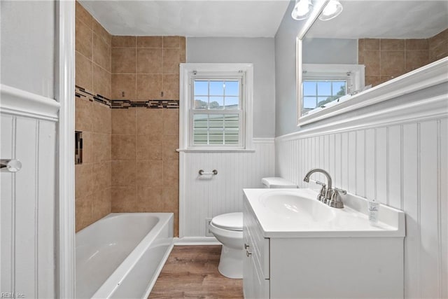 full bathroom with tiled shower / bath, toilet, vanity, and hardwood / wood-style flooring