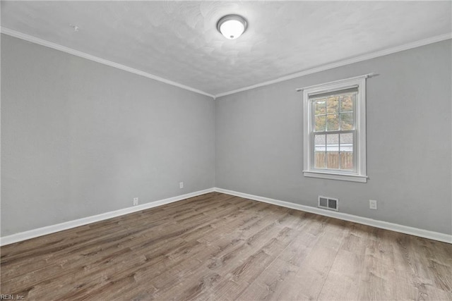 spare room featuring light hardwood / wood-style floors and ornamental molding