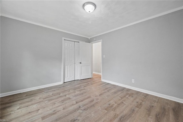 unfurnished bedroom featuring a closet, crown molding, and light hardwood / wood-style flooring