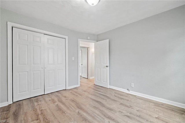 unfurnished bedroom with a closet and light wood-type flooring