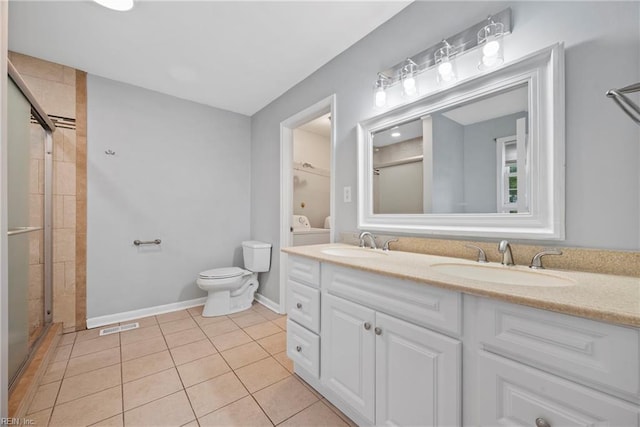 bathroom with tile patterned floors, vanity, toilet, and an enclosed shower