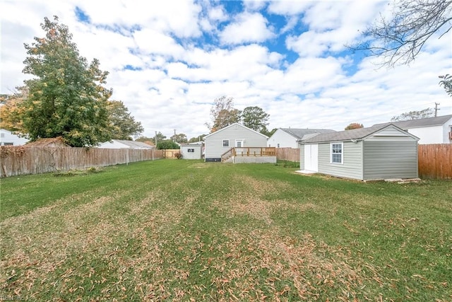 view of yard featuring a deck and a storage shed