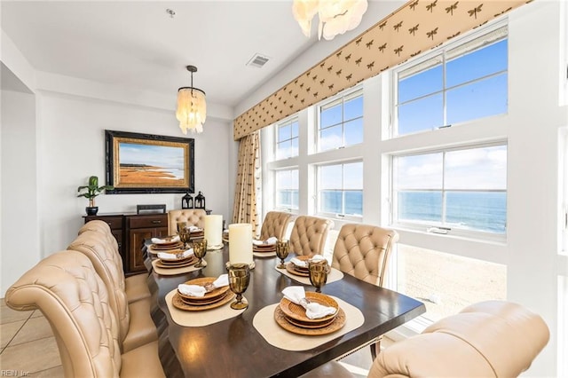 dining room featuring a water view and light tile patterned flooring