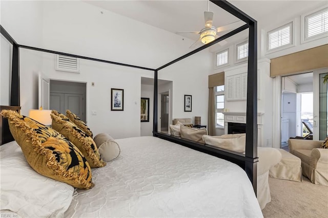 carpeted bedroom with a towering ceiling and ceiling fan