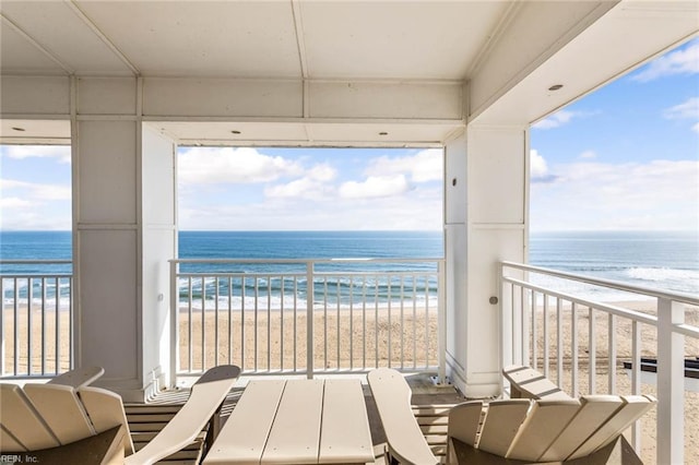 balcony featuring a water view and a beach view