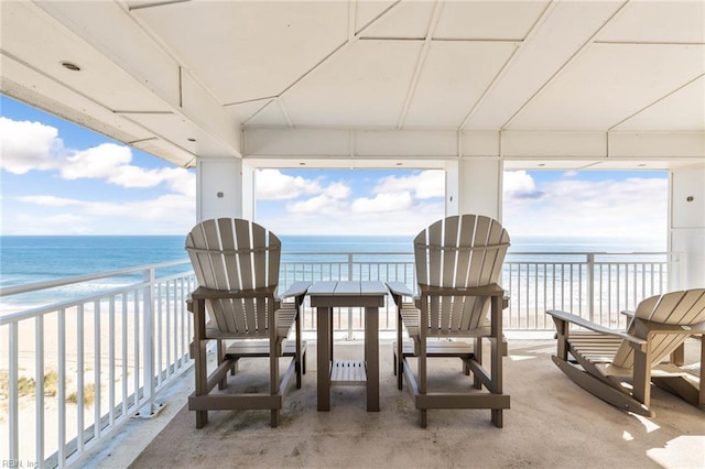 sunroom / solarium with a water view and a beach view