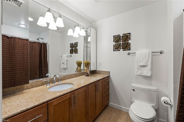 bathroom with vanity, toilet, hardwood / wood-style flooring, and a notable chandelier