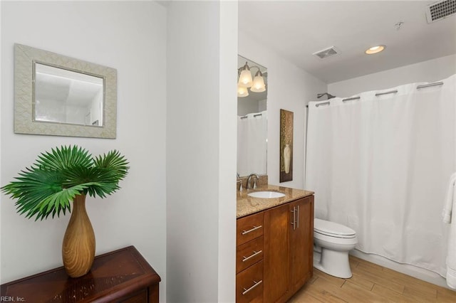 bathroom featuring vanity, hardwood / wood-style flooring, and toilet