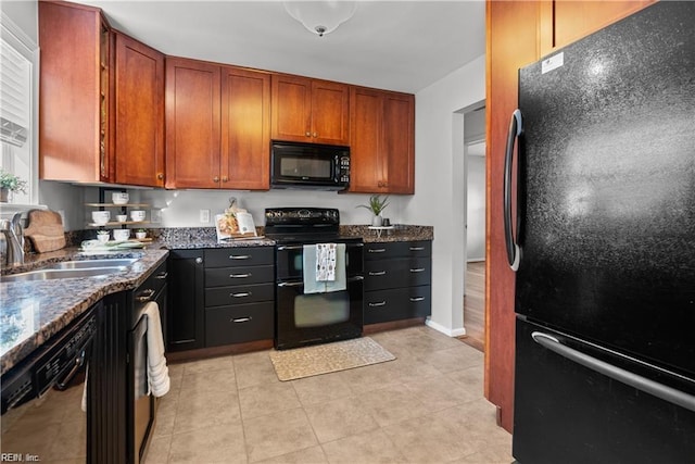 kitchen with black appliances, light tile patterned floors, sink, and dark stone counters