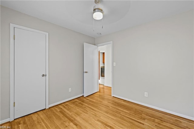 unfurnished bedroom with ceiling fan and light wood-type flooring