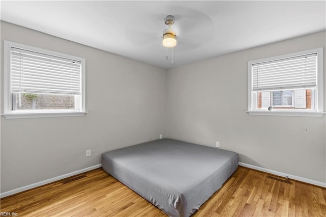 unfurnished bedroom with ceiling fan and light hardwood / wood-style floors