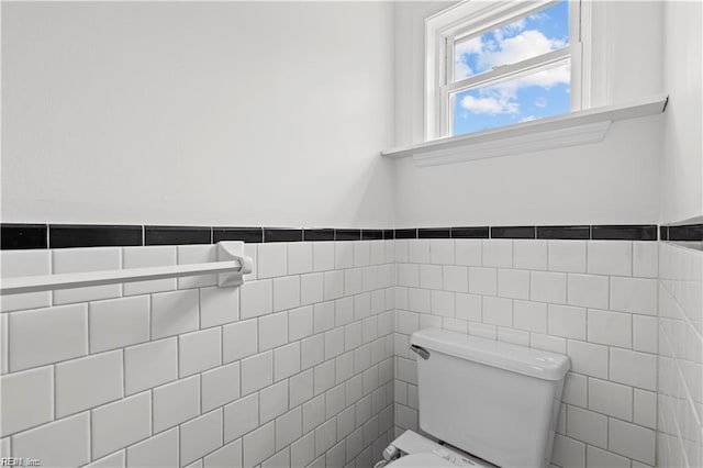 bathroom with tile walls and toilet