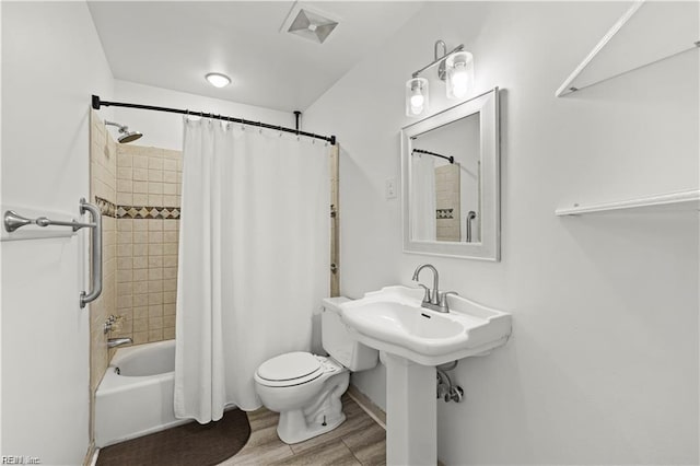 bathroom featuring hardwood / wood-style floors, toilet, and shower / bath combo with shower curtain