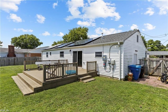 rear view of property featuring a yard and a wooden deck