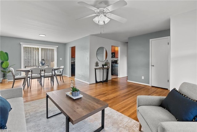 living room featuring ceiling fan and wood-type flooring