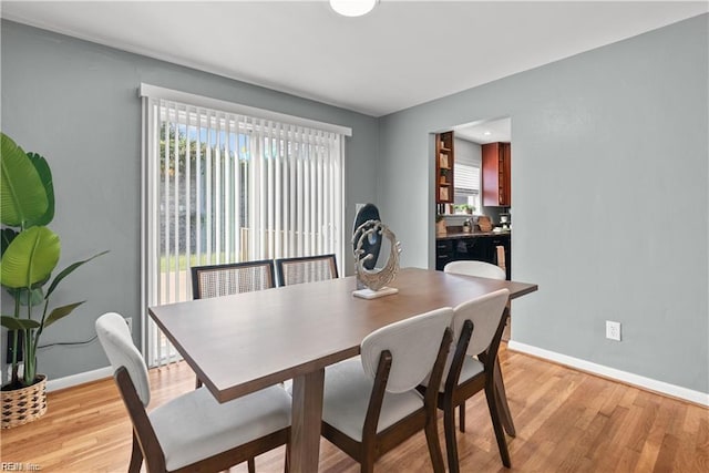 dining area with plenty of natural light and light hardwood / wood-style flooring