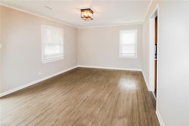 spare room with ornamental molding and hardwood / wood-style floors