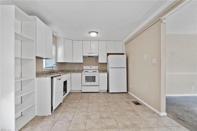 kitchen with white cabinets, light stone countertops, sink, light colored carpet, and white appliances