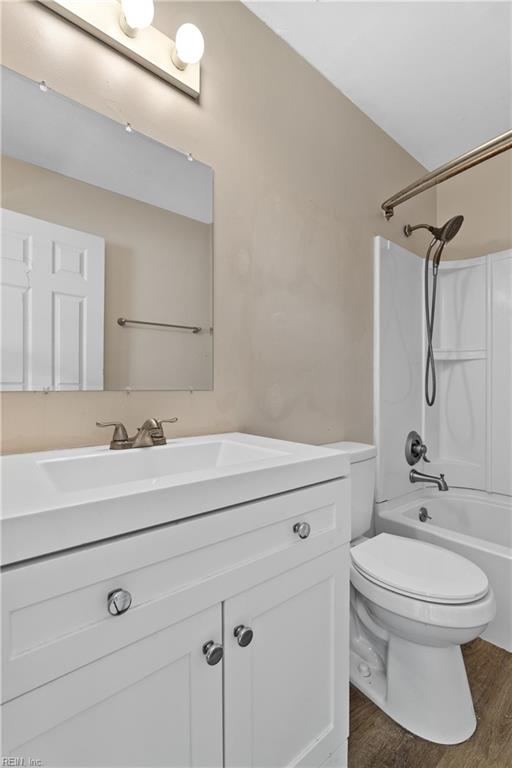 full bathroom with vanity, hardwood / wood-style floors, toilet, and shower / bath combination