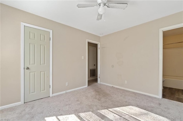 unfurnished bedroom with ceiling fan, light carpet, and ensuite bath