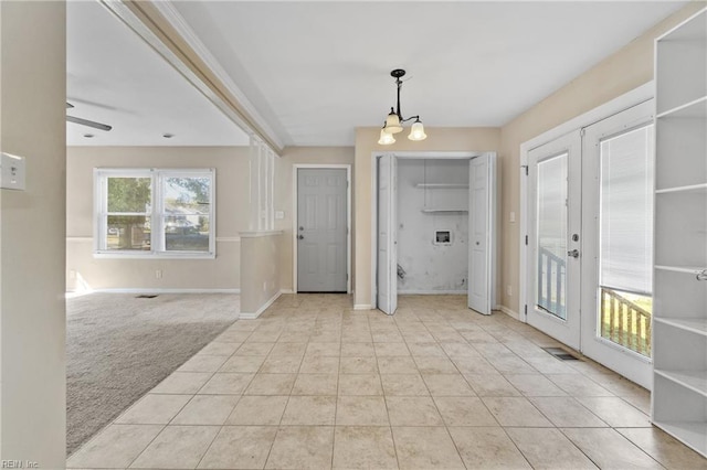 entryway with french doors, light colored carpet, and ceiling fan with notable chandelier