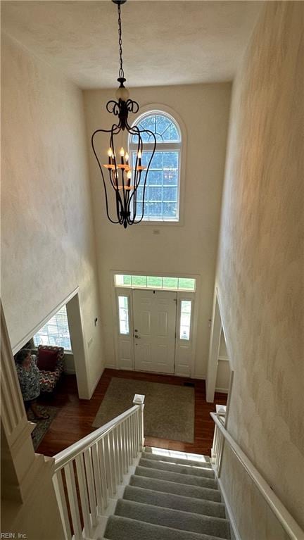 entryway featuring a chandelier, dark hardwood / wood-style floors, and a towering ceiling