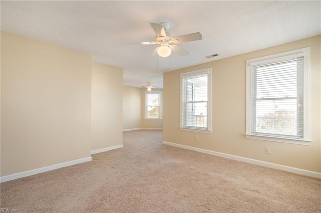 unfurnished room featuring light carpet and ceiling fan