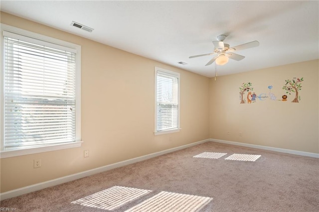 carpeted spare room featuring ceiling fan