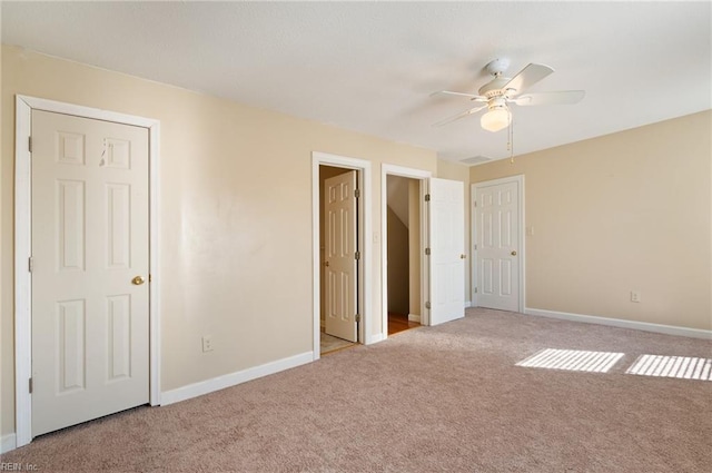 unfurnished bedroom with light colored carpet and ceiling fan