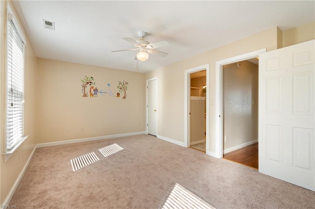 unfurnished bedroom with light carpet, multiple windows, and ceiling fan