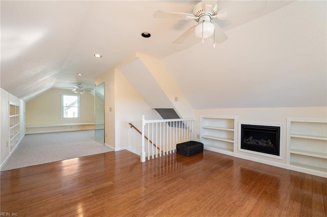 additional living space with ceiling fan, wood-type flooring, lofted ceiling, and built in shelves