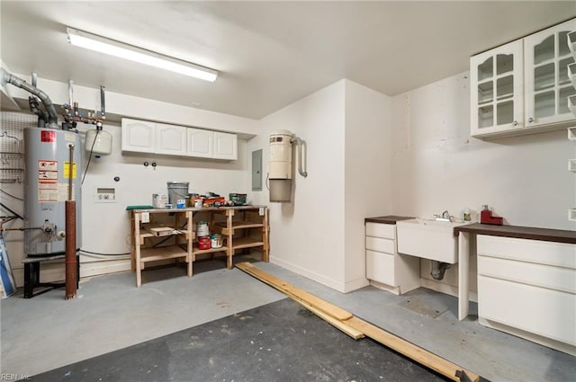 garage with water heater, electric panel, sink, and a workshop area