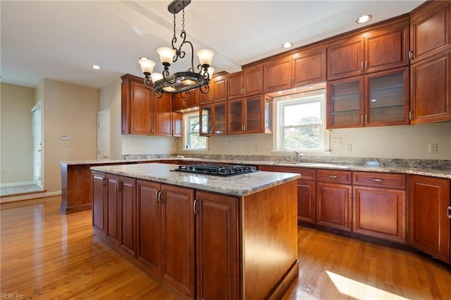 kitchen featuring a kitchen island, light hardwood / wood-style flooring, decorative light fixtures, and a chandelier