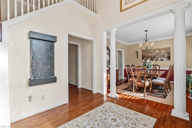 foyer entrance with ornamental molding, a chandelier, wood-type flooring, and a high ceiling