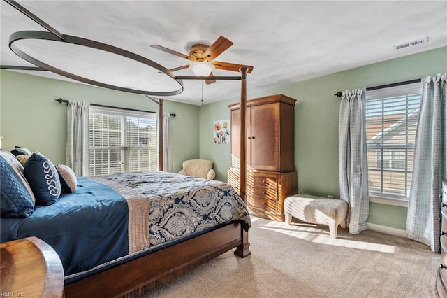 carpeted bedroom featuring ceiling fan and multiple windows