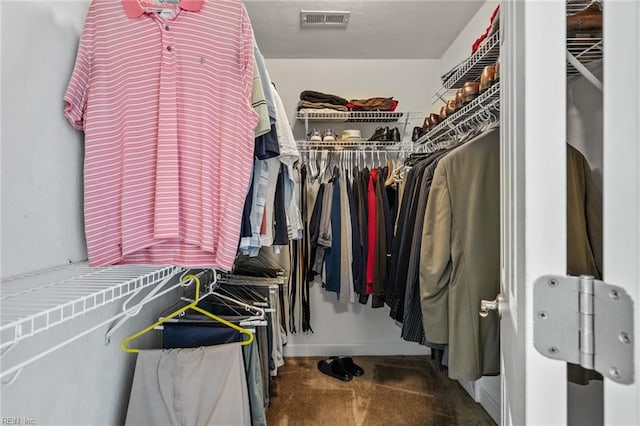 spacious closet with dark colored carpet