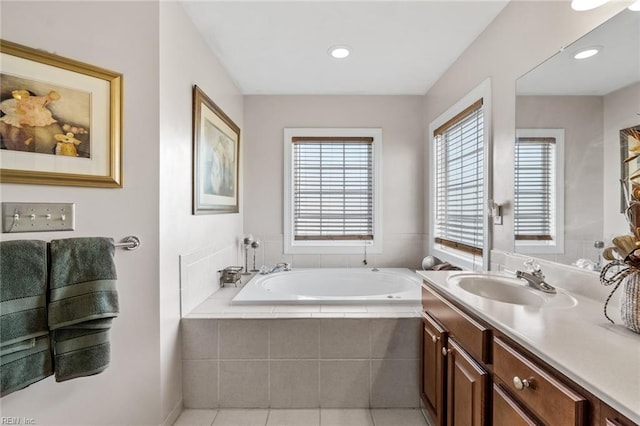 bathroom featuring vanity, a relaxing tiled tub, and tile patterned floors