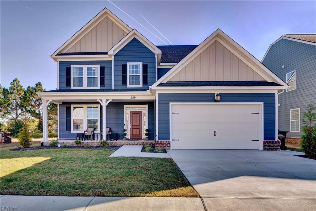 craftsman house featuring a front lawn, covered porch, and a garage