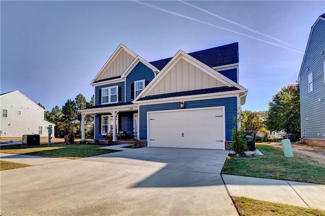 craftsman house with cooling unit, a front lawn, covered porch, and a garage