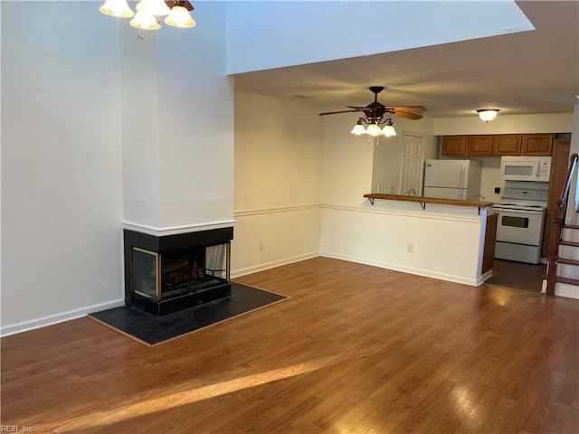 unfurnished living room with ceiling fan, a multi sided fireplace, and dark hardwood / wood-style floors